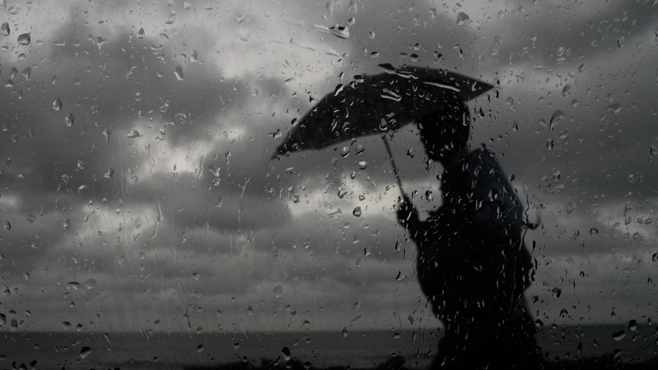 资料图：一名男子撑伞在雨中行走。 / Thilina Kaluthotage/NurPhoto via AFP