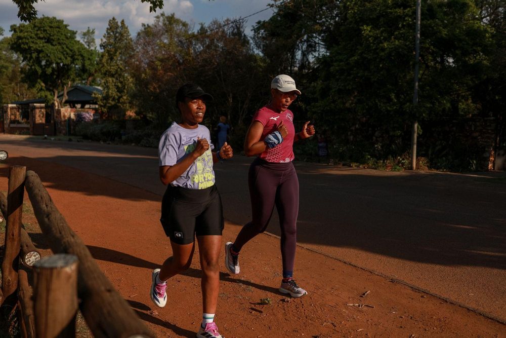 Nancy Masha（左）与Babalwa Melitafa在Irene一处封闭社区内、板球场旁跑步。 / Phill Magakoe / AFP ...