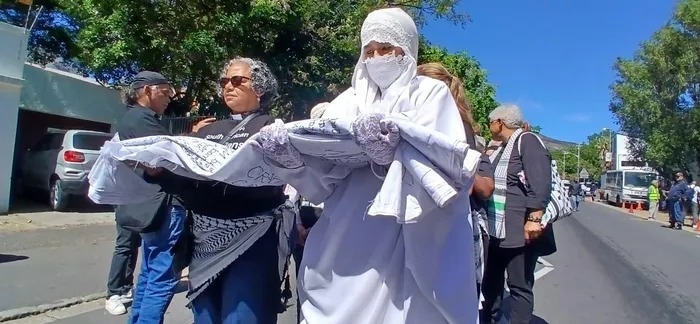 参与者抬着写有巴勒斯坦儿童姓名的长布，沿开普敦市中心前往圣乔治大教堂。 / Robin-Lee Francke / IOL ...